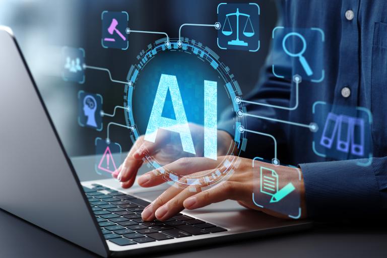 Person using laptop with the letters AI floating above the laptop