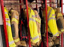 a row of hanging firefighter jackets